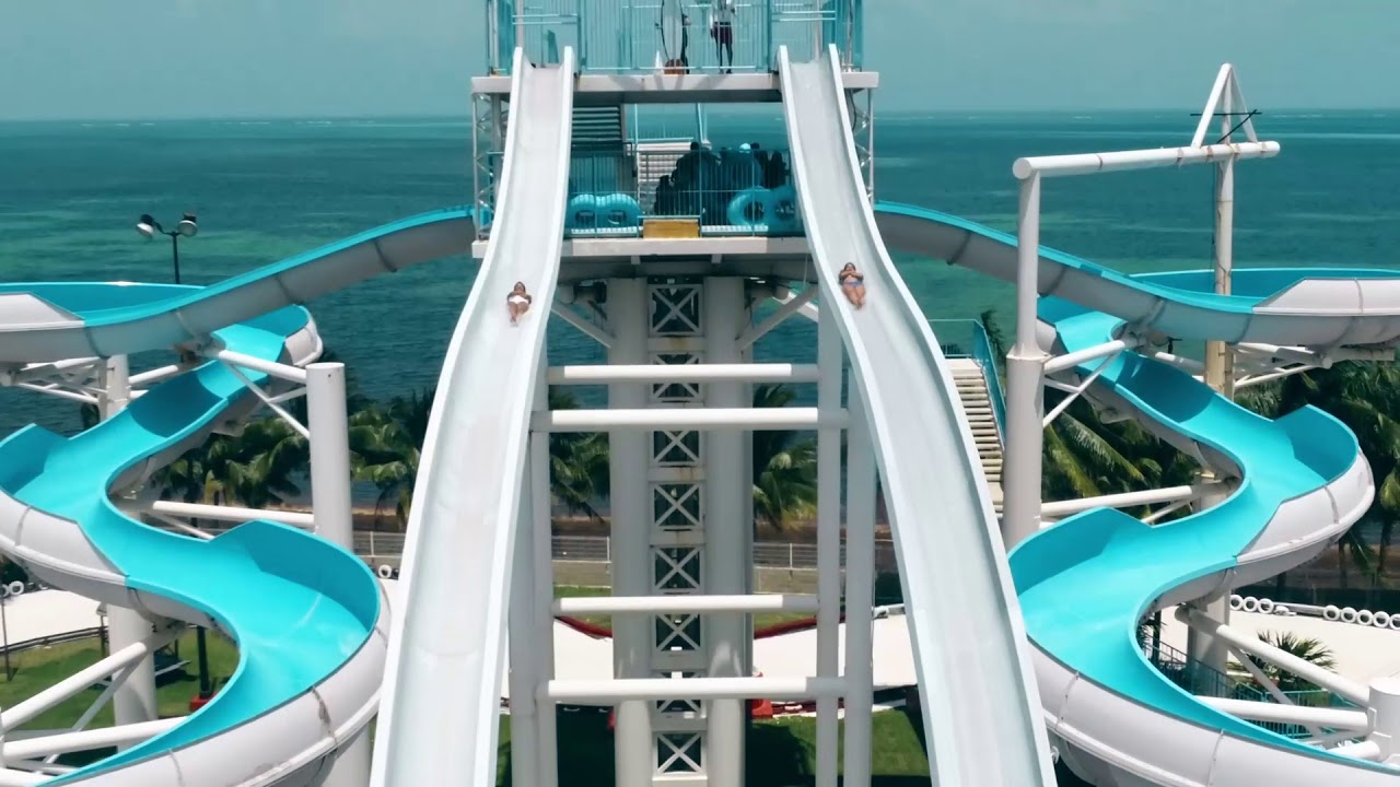 Two people sliding down a large water slide. 