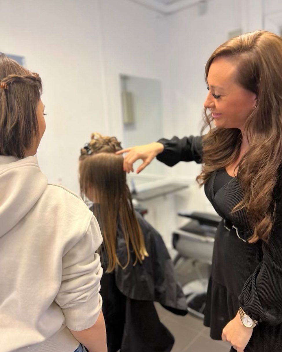 Göteborg Frisörskola lärare som visar en elev hur man klipper håret ordentligt på en kund