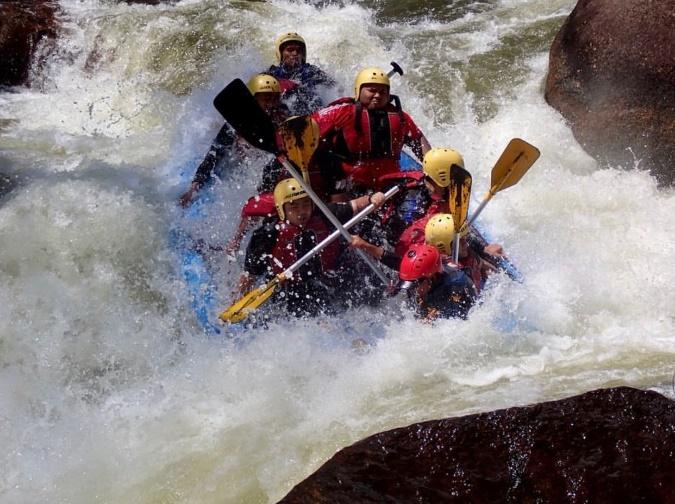 A person riding a wave on a raft in a body of water

Description automatically generated