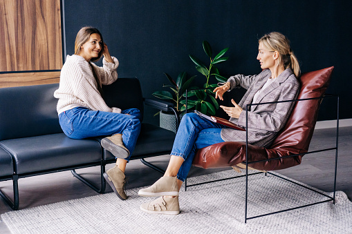 A woman attending therapy for anxiety and depression and talking to her therapist who has a notepad on her lap.  Anxiety treatment in Los Angeles, CA can help with coping skills by talking to an anxiety therapist. 91364 | 91307 | 91356 | 91301 | 91302 | 91372
91367 