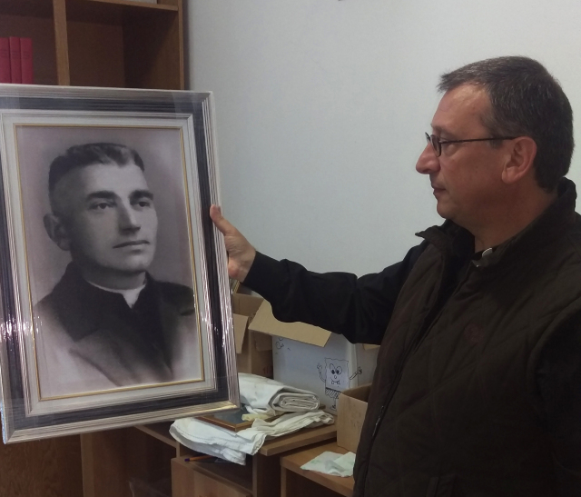 Franciscan Brother Vincenzo Foca holds a photo of Father Luigj Prendushi in Shkoder, Albania. Father Prendushi was killed in Albania under that country's former atheist regime and Brother Vincenzo has spent the last 24 years locating bodies of Catholics in Albania, some of whom, like Father Prendushi, are on Pope Francis' list of martyrs. (CNS/James Martone)