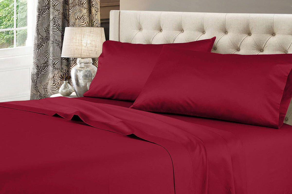A bed made with a set of Egyptian Linen sheets in burgundy.