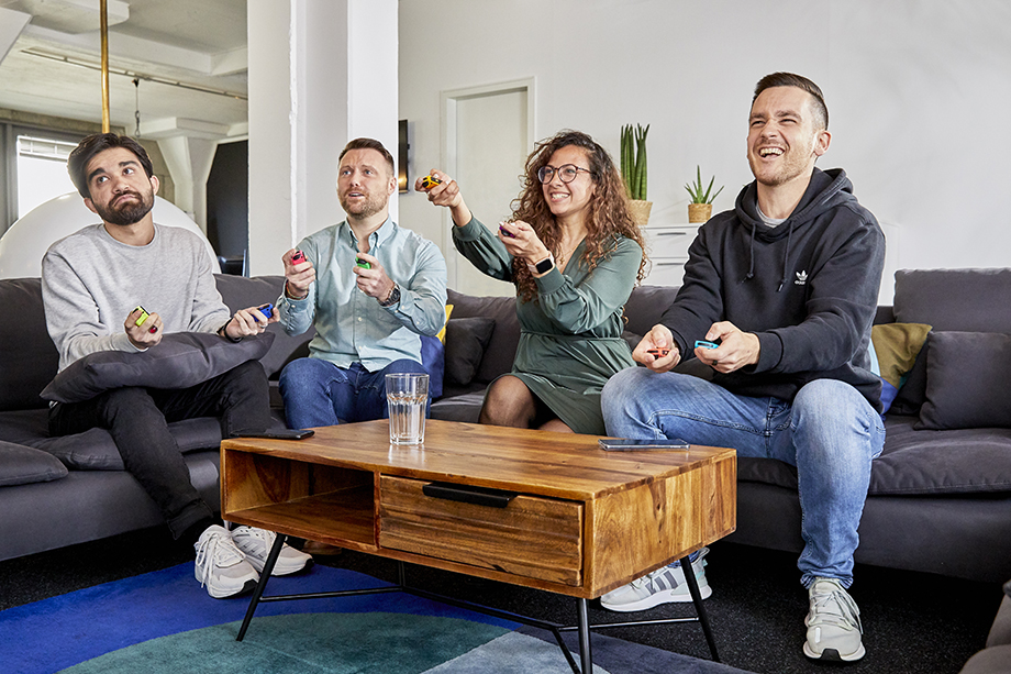 A portrait of coworkers playing a game on a couch in their Berlin office, photographed by Viviane Wild