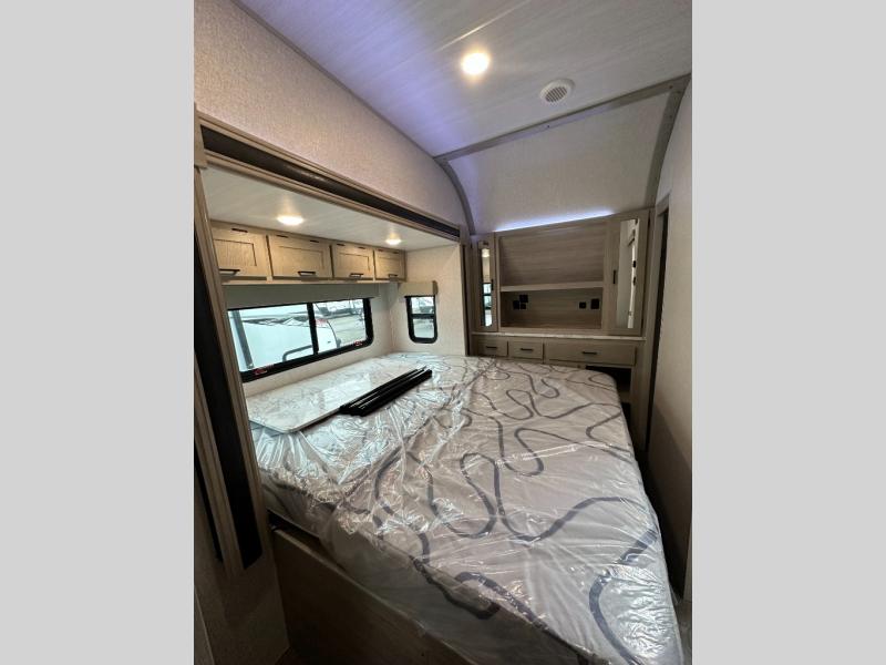 Bedroom and king bed in a toy hauler travel trailer