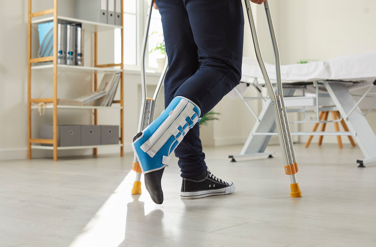 FMLA Illinois: injured person with a cast on a leg using crutches