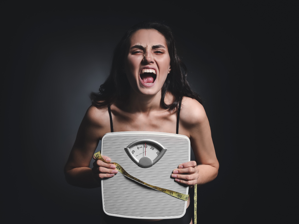 Skinny woman holding a weight scale