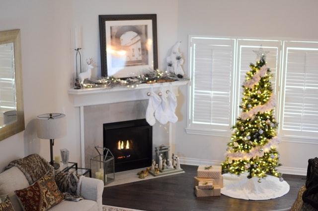 A living room with a fireplace and a christmas treeDescription automatically generated with medium confidence