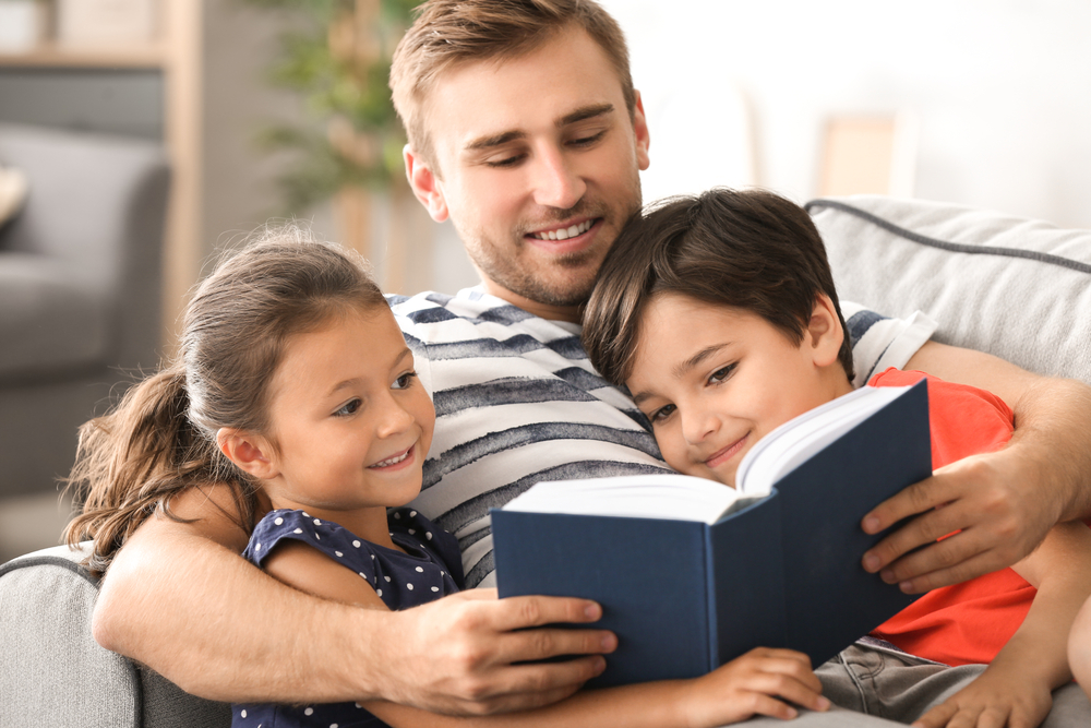 Dad reading to his children and explaining adjectives for kids