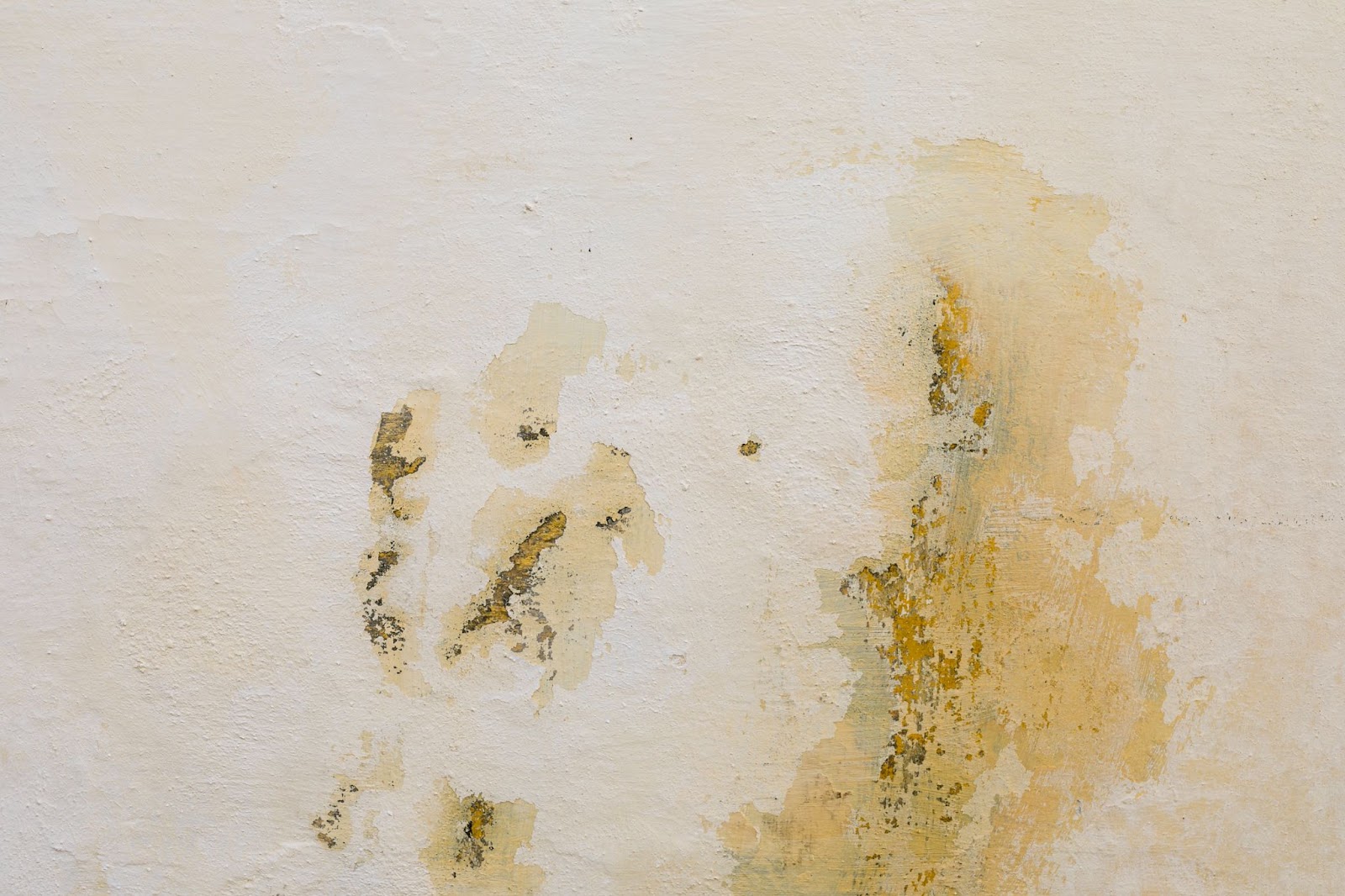 A beige wall covered in water stains