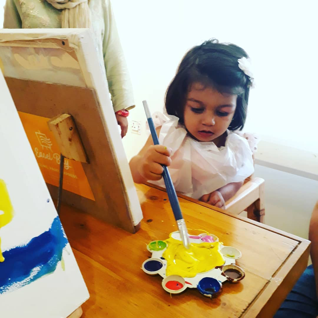 Little girl painting during class 
