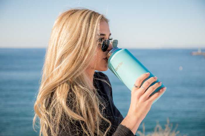 An iamge of a woman using a reusable bottle