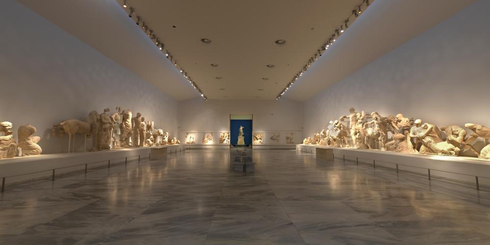 The central hall is breathtaking with the sculptural decoration of the temple of Zeus and the statue of Nike of Paionios in the background – © Hellenic Ministry of Culture and Sports / Ephorate of Antiquities of Ilia (efailias)