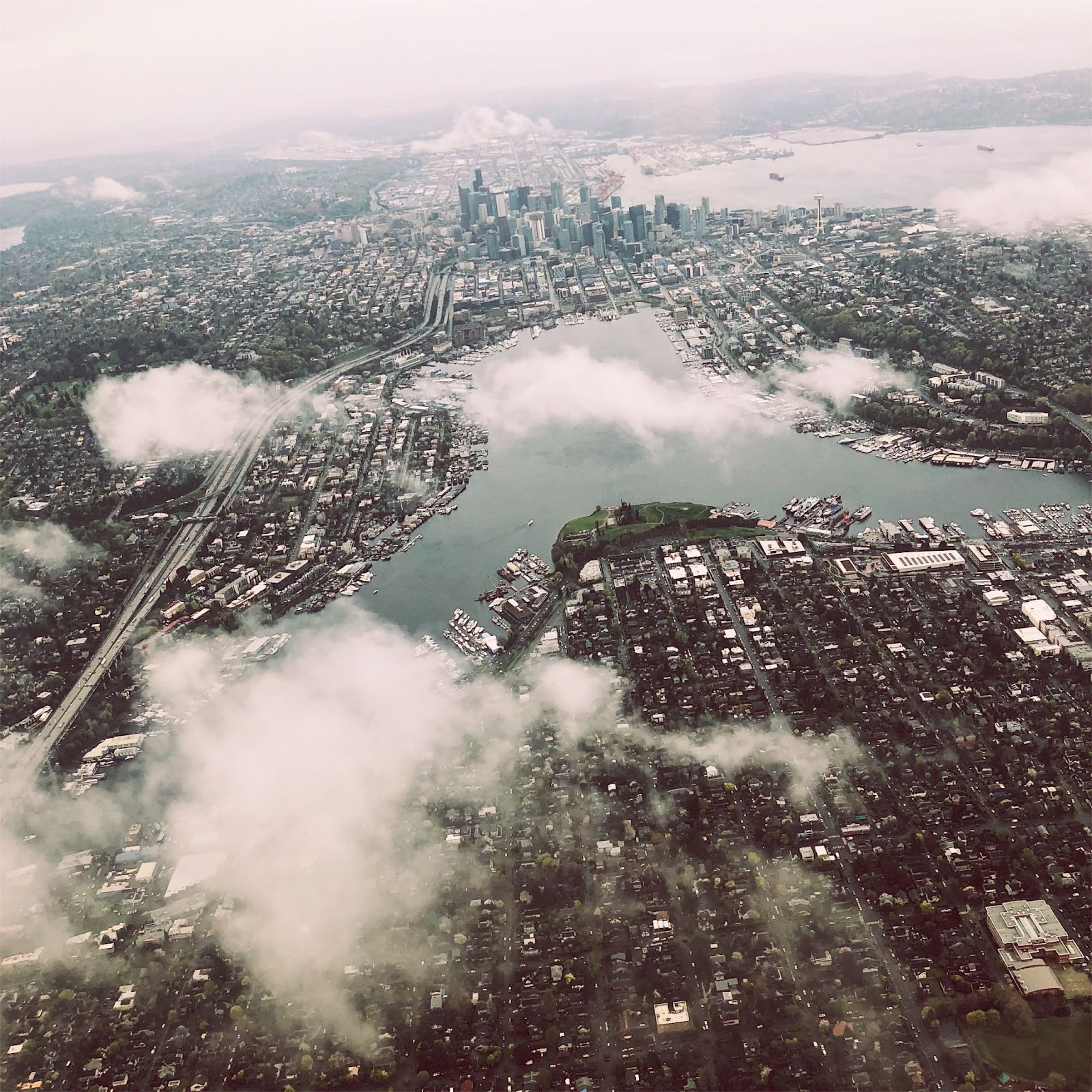 Aerial view of Seattle looking at downtown and Lake Union through low clouds.