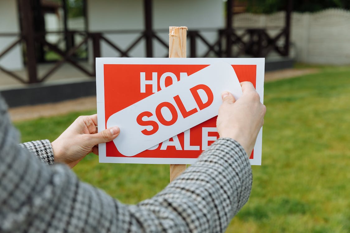 Free Shallow Focus Photo of a Realtor Posting a Sold Sticker Stock Photo