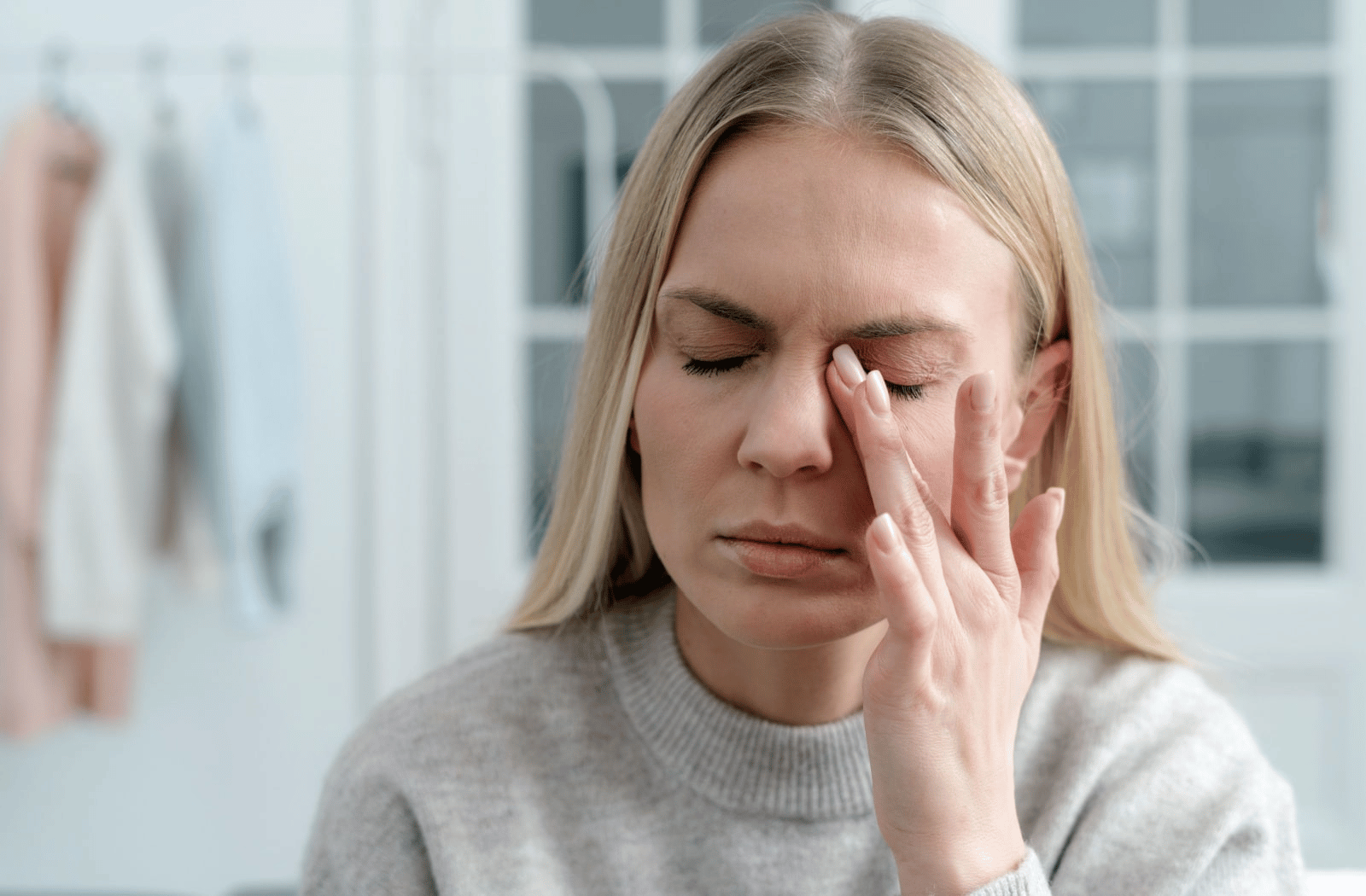 A woman dealing with headaches as a symptom of dry eyes.