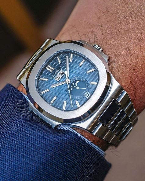 A person wearing a blue and silver watch.