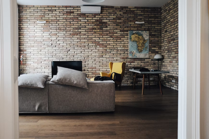 A living room with brick wall and a wall mural of Africa