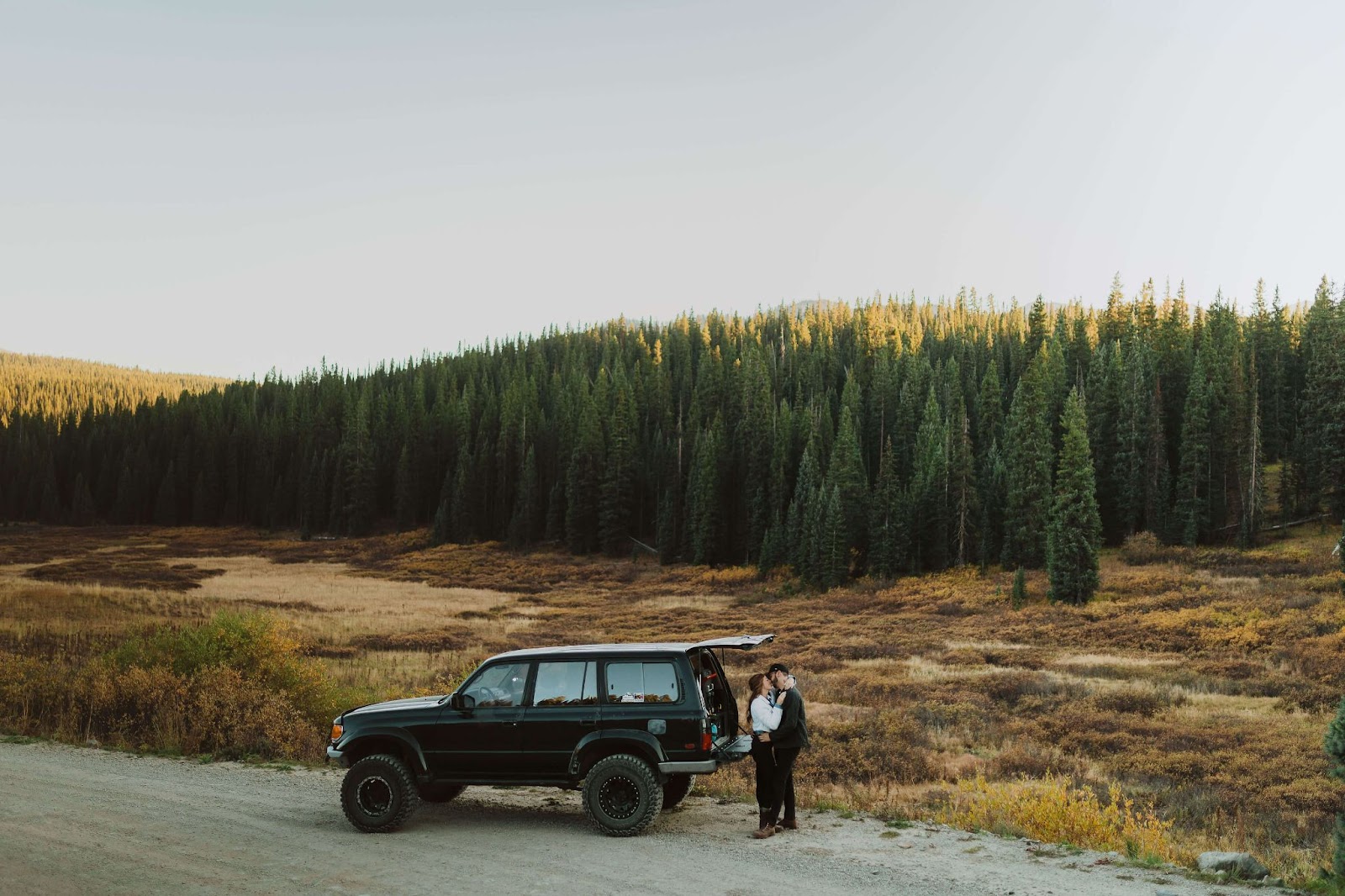 Jeep & couple embracing behind jeep