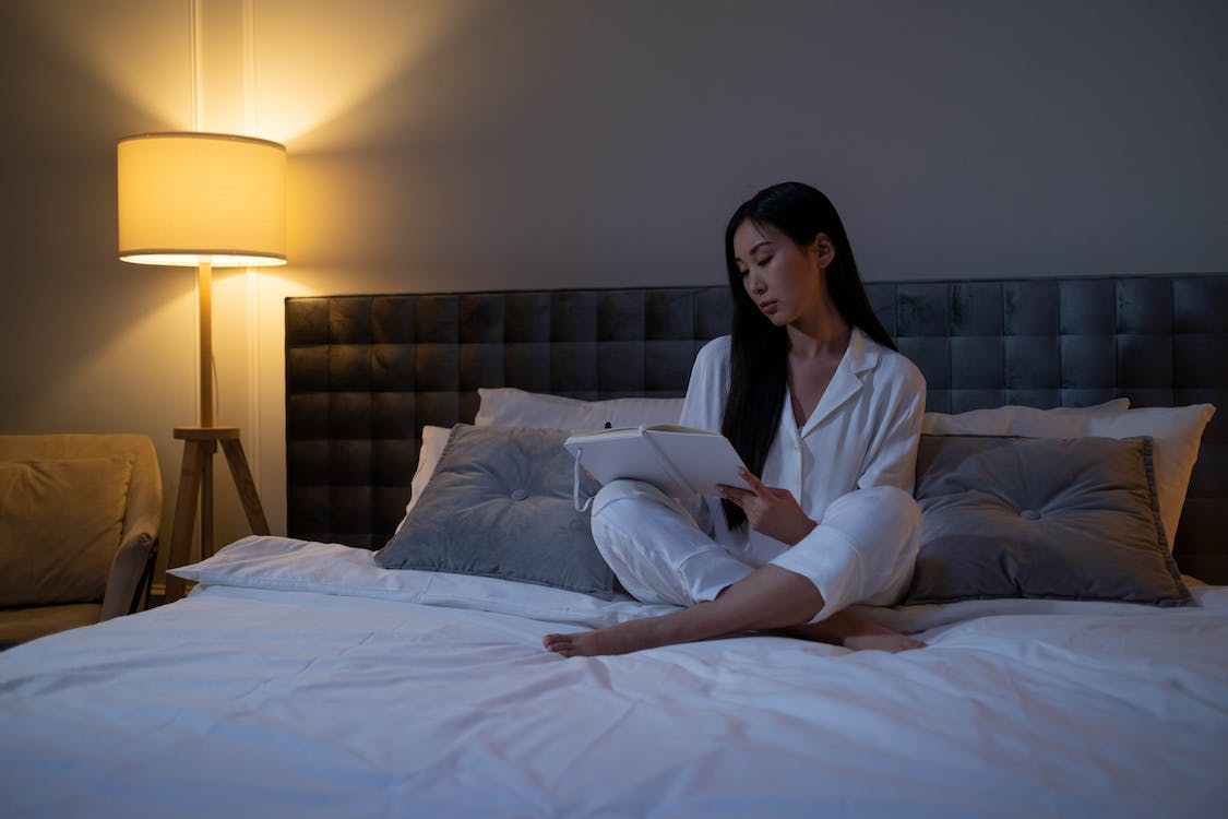 a person sitting on a bed journaling