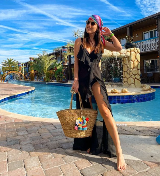 A person holding a purse by a pool

Description automatically generated with medium confidence