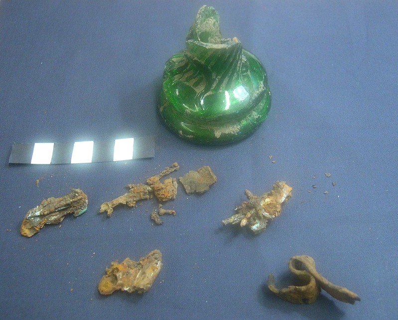 Green and gold broken bottle fragments on blue cloth