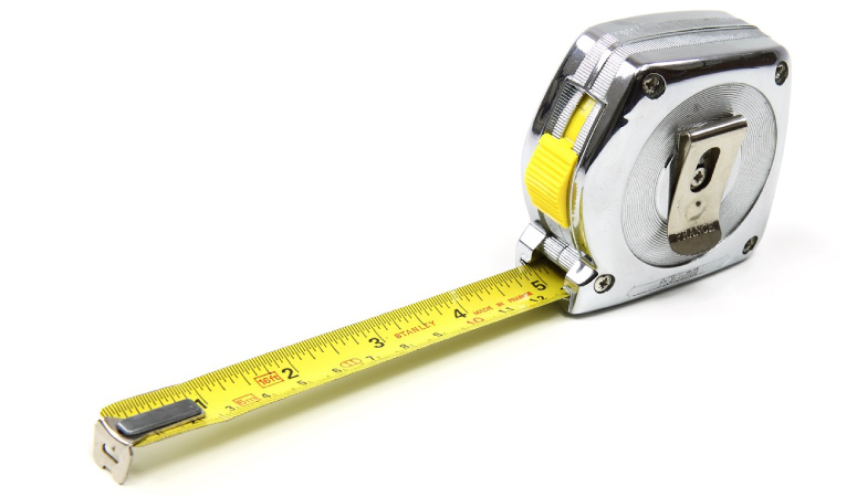 A metal measuring tape with the tape extended five inches.