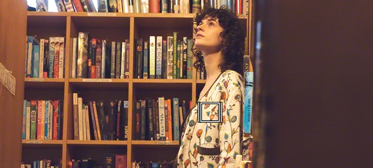 A woman browsing in a library - a white square denotes Object Tracking for video