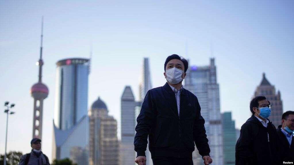 戴着口罩的行人行走在上海陆家嘴金融区的街道上。(2020年3月19日)