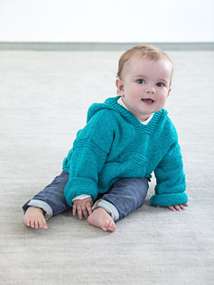 baby wearing aqua hoodie sitting on floor