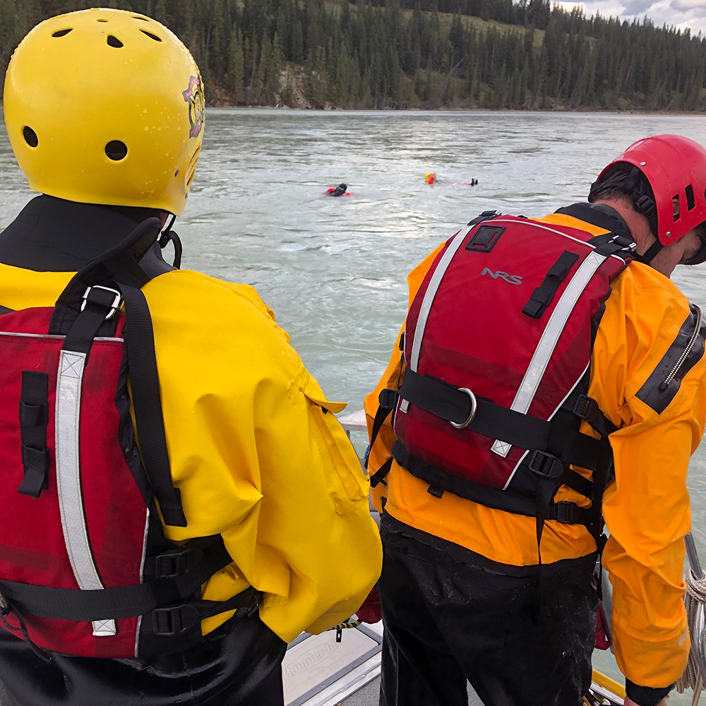 Carleton Rescue performing a contact rescue during a swift water training operation with many emergency responders on board.