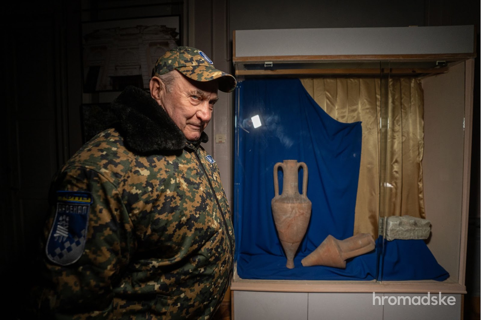 Охоронець Анатолій Матвієнко зачаровано розглядає стародавню амфору за музейною вітриною