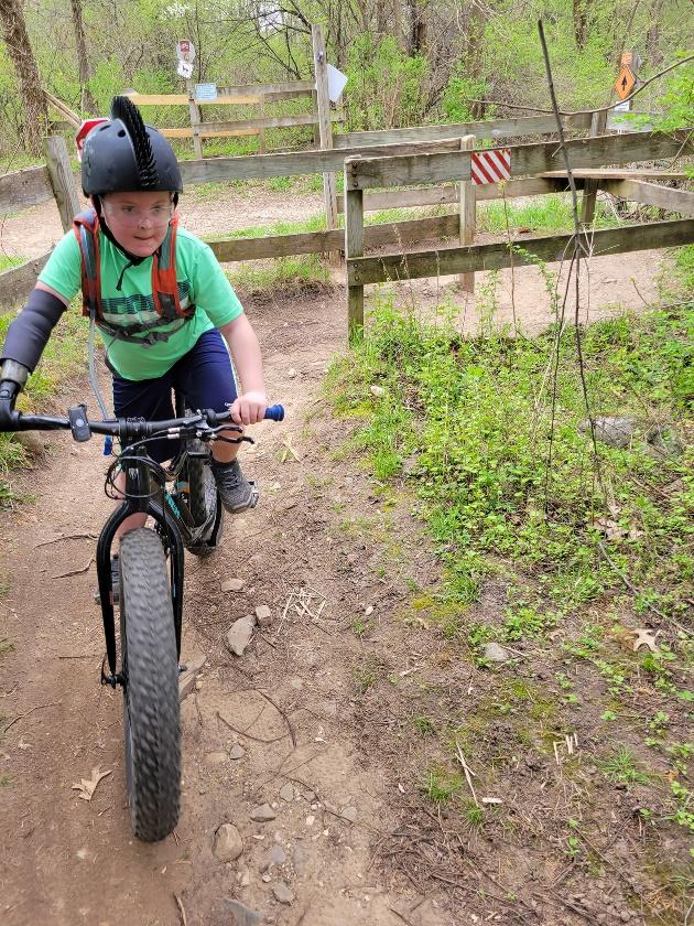 A child riding a bike on a dirt path

Description automatically generated with low confidence