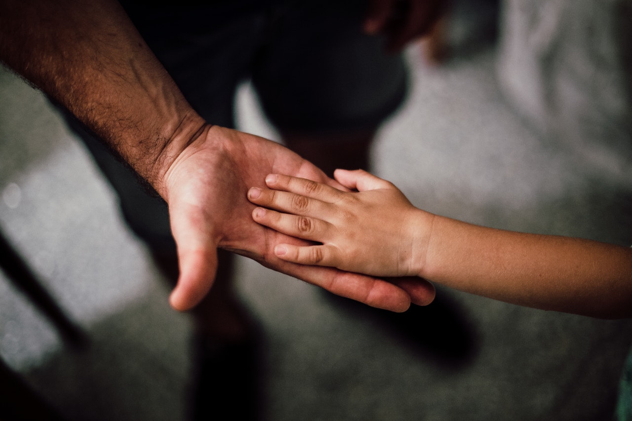 Father holding child’s hand. When does child custody end?