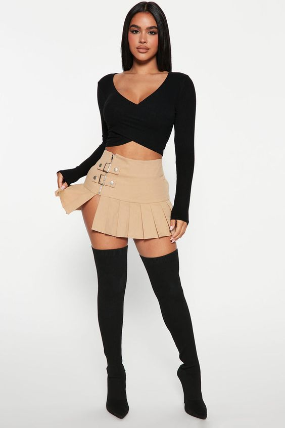 lady wearing black top with brown micro mini skirt and black knee-high boots