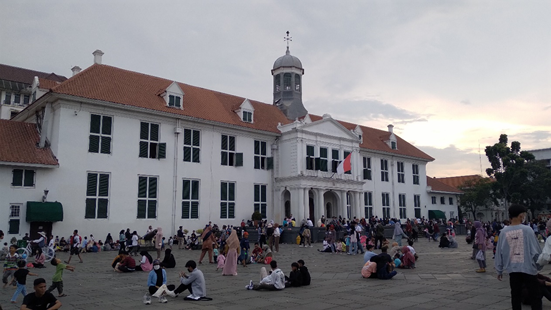 Gedung Museum Sejarah Jakarta dan orang-orang yang duduk di sekitar Taman Fatahillah. (Sumber foto: Dok. pribadi penulis)