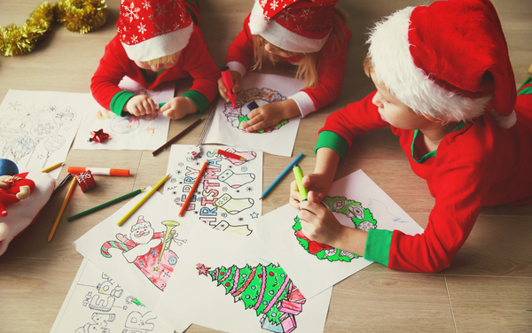 children laying on floor in santa hats coloring