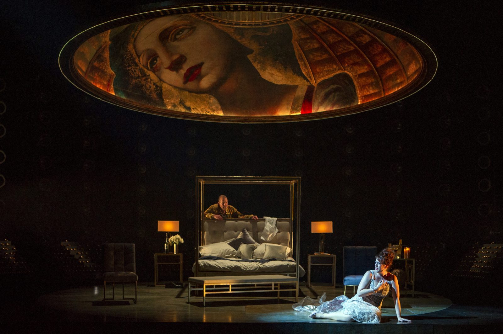 person lay next to a bed, part of the opera performance of Tosca.