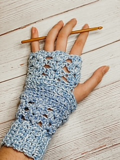 hand holding crochet hook and wearing a fingerless glove