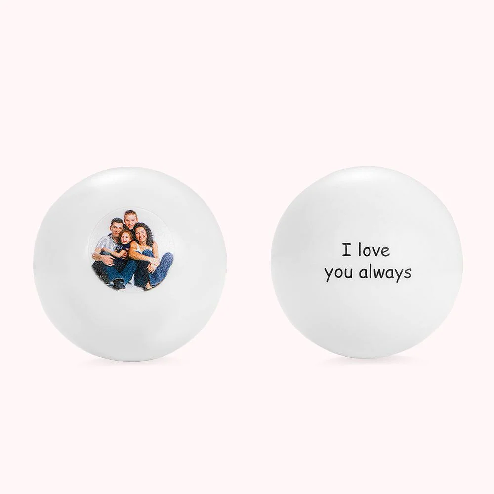 Deux boules de billard représentant la face avant et la face arrière d’une même boule blanche, avec à l’avant une photographie de famille, et à l’arrière la phrase I love you always. 