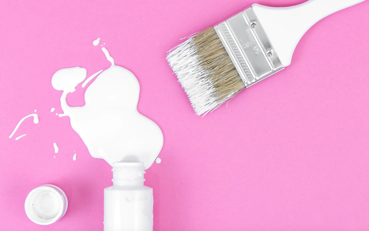 White paint splashed on pink background. Keep reading to get the best blogging tools for beginners, bloggers and content creators. 