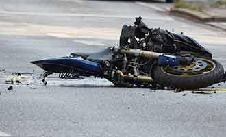 A severely damaged motorcycle in the roadway after an accident.