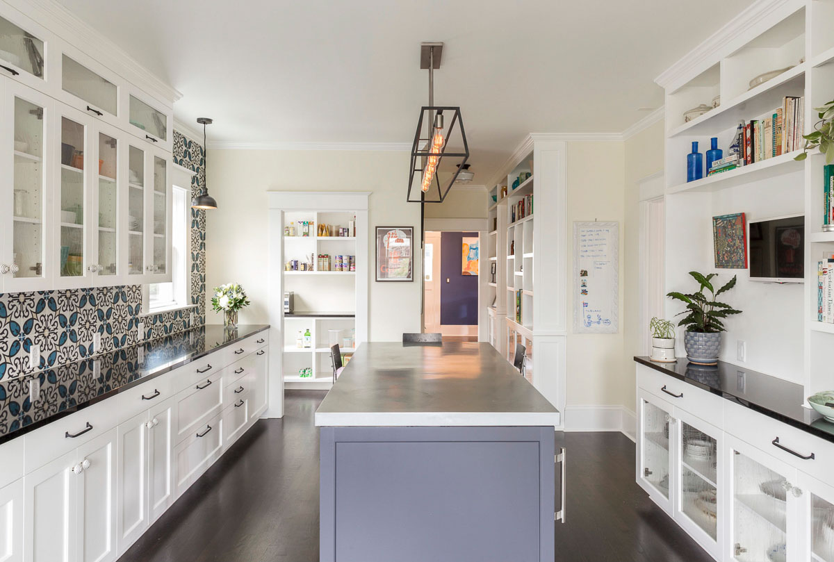 modern kitchen with flower backsplash, white cabinets, and a kitchen island