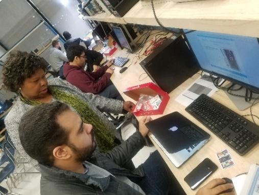 A group of people sitting at desks with computers

Description automatically generated with low confidence