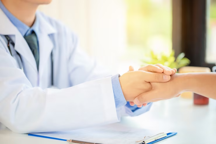 Doctor's hands holding patient's hand, illustrating empathy and support in medical interactions.