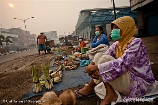 Market vendors in Dumai wear masks to protect themselves from air pollution caused by the forest fires in Sumatra. 23 Jun, 2013