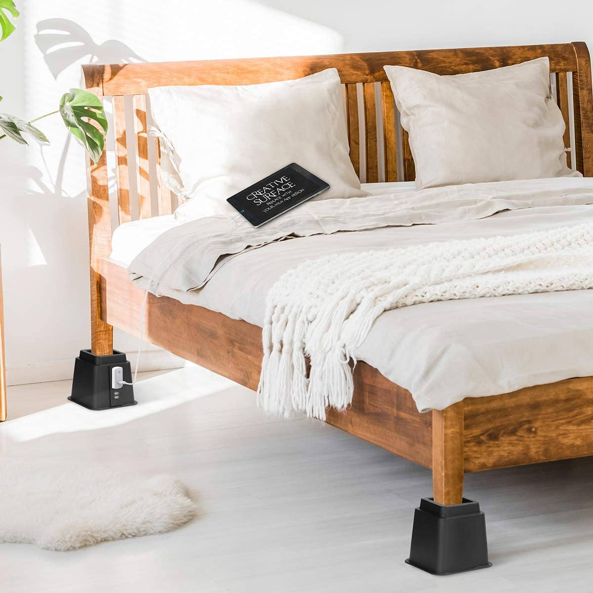 Use bed risers to increase under-bed storage to fit more items along with a sleigh bed in a small apartment bedroom.