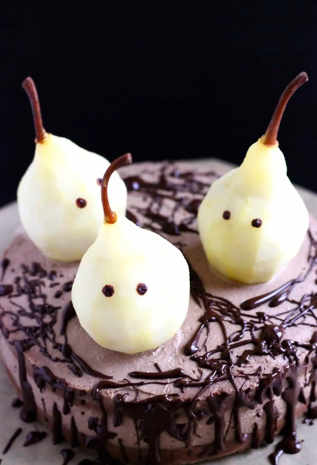 Halloween themed cake decorated with pears designed to look like ghosts. 