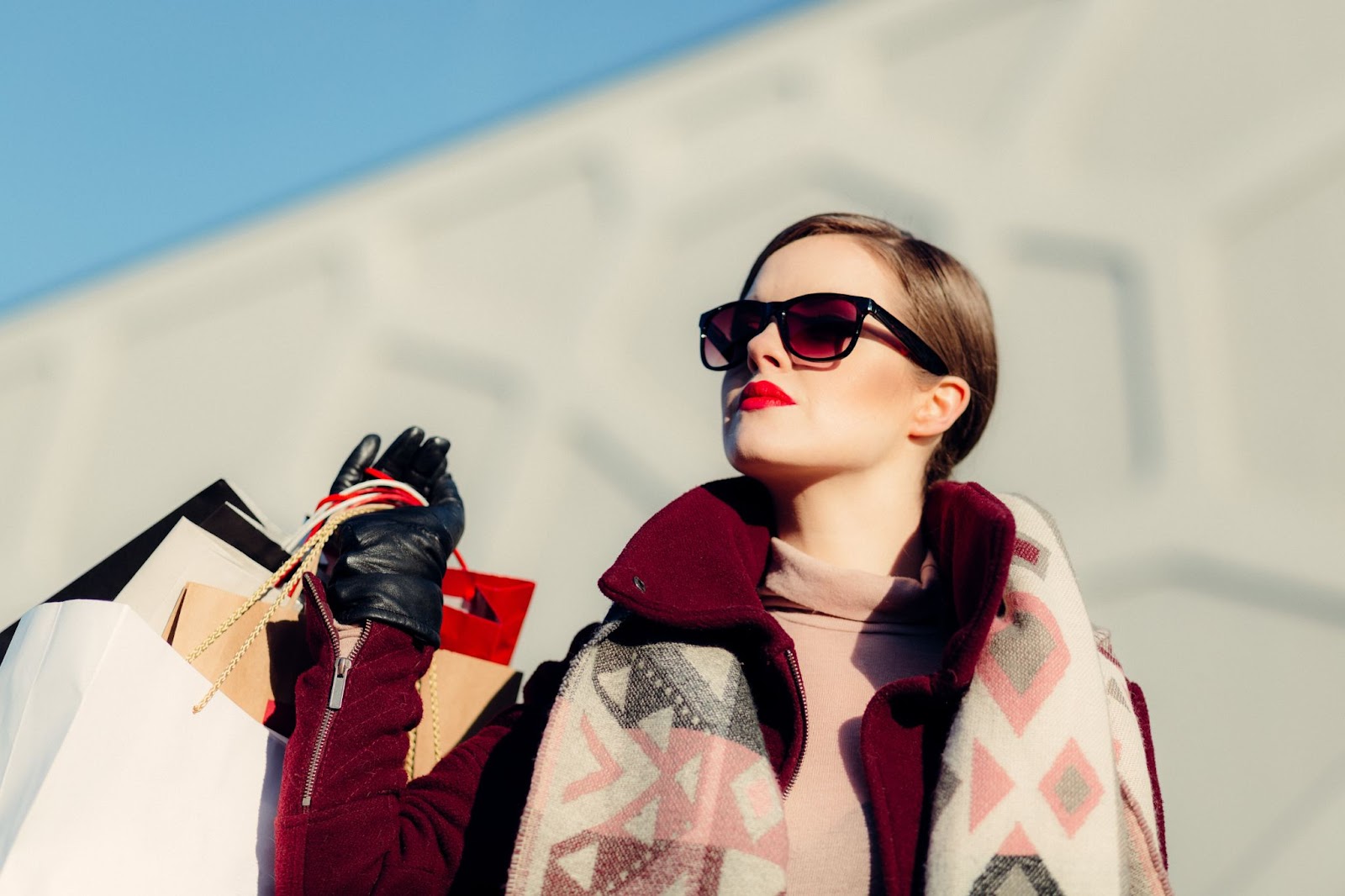 a girl with sunglasses holding shopping bags