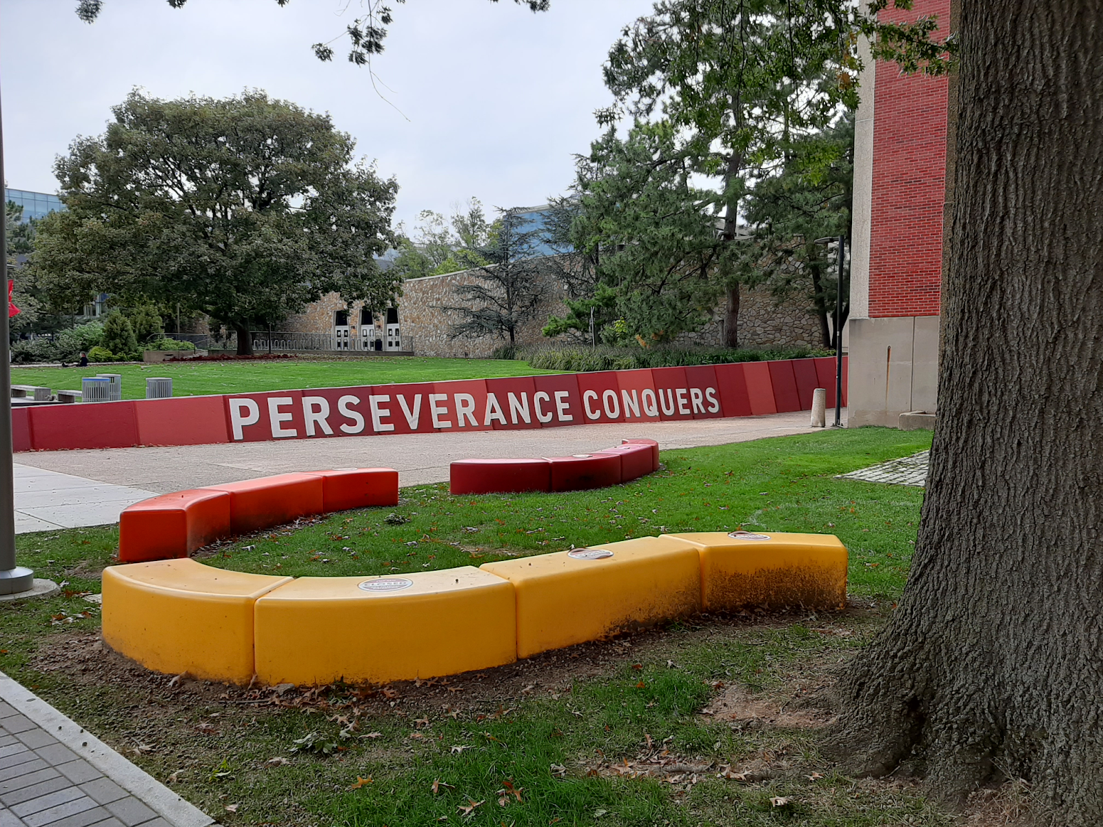 A picture of a sign on Temple University's main campus. It reads "Perseverance Conquers".