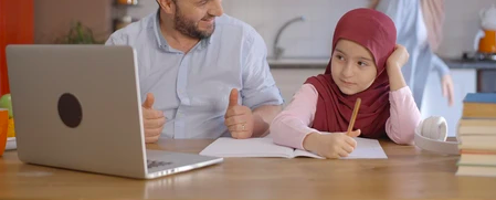 A Muslim tutor teaching a little kid